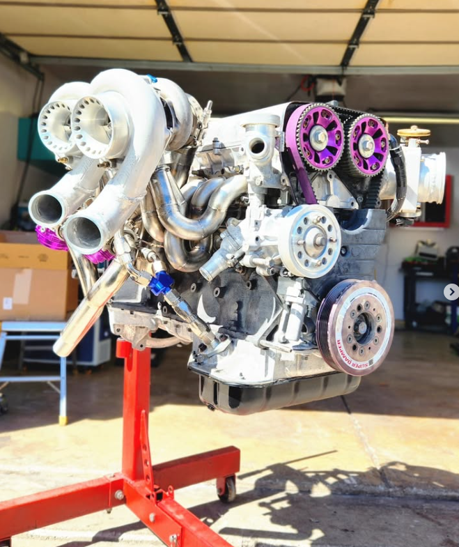Fully assembled twin-turbo engine on a stand, with freshened Precision turbos, custom manifolds, and purple cam gears and wastegates installed
